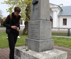 Uczeń zapala znicz przed pomnikiem S. Staszica w Jarosławcu