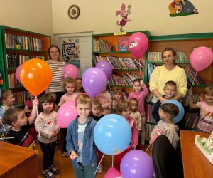 Zdjęcie przedstawia dzieci pozujące do zdjęcia wraz z opiekunem.