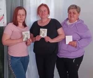 Zdjęcie przedstawia trzy kobiety pozujące do zdjęcia wewnątrz budynku.