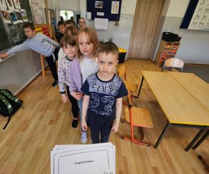 Uczniowie ustawieni w kolejce do udziału w zabawie edukacyjnej.