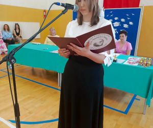Uczennica klasy ósmej recytuje przy mikrofonie