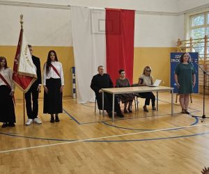 poczet sztandarowy oraz pani dyrektor z nauczycielami podczas uroczystości rozpoczęcia roku szkolnego