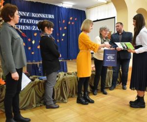 Grupa ludzi przy scenie, wręczanie nagród.