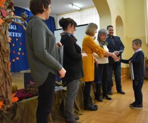 Grupa ludzi przy scenie, wręczanie nagród.