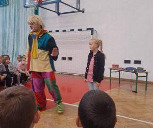 Dziewczynka stoi obok klowna