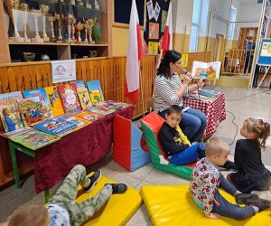 Nauczycielka czyta książkę, dzieci słuchają