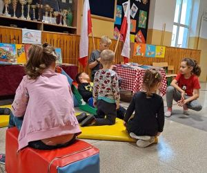 Chłopiec czyta książkę, dzieci słuchają