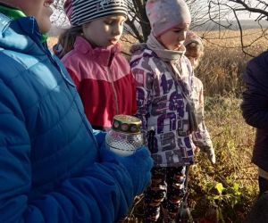 Uczniowie klas 1-3 zapalają znicze na mogile