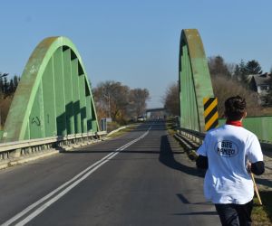 Most na drodze. Jedna osoba biegnie z pochodnią