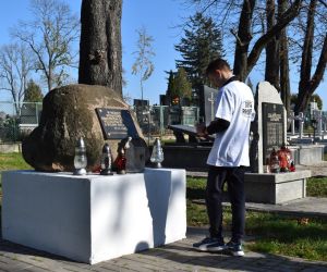 Pomnik na cmentarzu. Przed pomnikiem jedna osoba