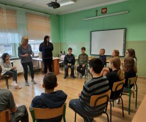 Prowadzące rozmawiają z uczniami, którzy siedzą w kole