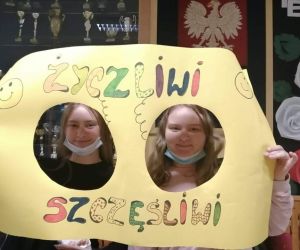 Uczennice klasy ósmej na tle plakatu życzliwi, szczęśliwi