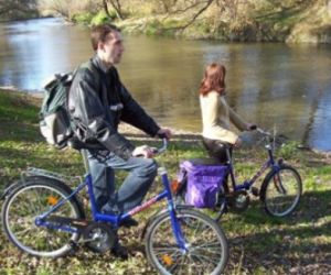 Mężczyzna i kobieta z rowerami, stoją na brzegu rzeki