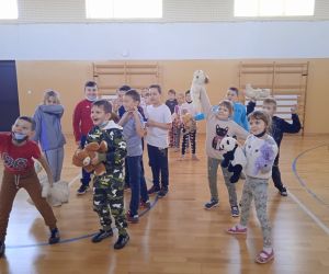 Uczniowie wykonują wesoły taniec z misiem