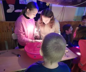 Uczennice leją wosk do miski z wodą