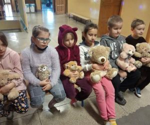 Dzieci trzymają ulubione maskotki i słuchają opowieści o misiach