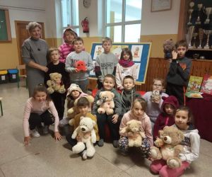 Opiekunowie i uczniowie, którzy trzymają ulubione maskotki pozują do zdjęcia