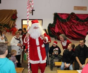 Mikołaj na środku sali pośród ludzi.