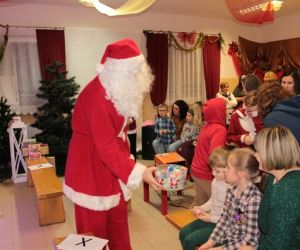 Mikołaj na środku sali pośród ludzi.