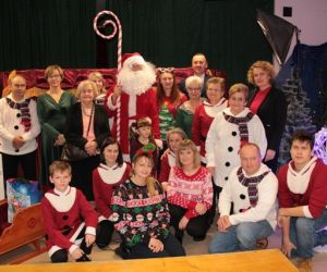 Grupa osób ze Świętym Mikołajem.