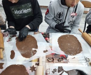 Uczniowie wykrawają różne kształty pierniczków z ciasta