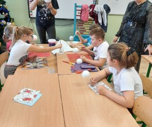 Uczniowie pokrywają klejem styropianowe bombki