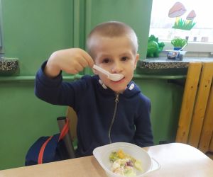 chłopiec je sałatkę owocową