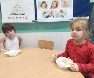 dziewczynki jedzą sałatkę owocową