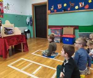 dzieci siedzą i oglądają teatrzyk