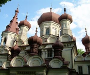 Brązowe kopuły cerkwi, fragmenty żółtych ścian, wąskie okna