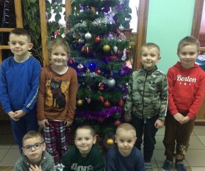 Dzieci stoją przy ubranej choince.