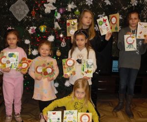 Dzieci stoją w grupie  i prezentują laurki wykonane podczas warsztatów.