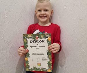Chłopiec prezentuje dyplom za zajęcie II miejsca