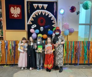 Uczniowie klasy pierwszej w strojach karnawałowych  wychowawczynią