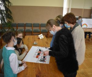 Dzieci wewnątrz budynku siedzą a Pani należące do Komisji Konkursowej przypatrują się rozwiązaniom zadania.