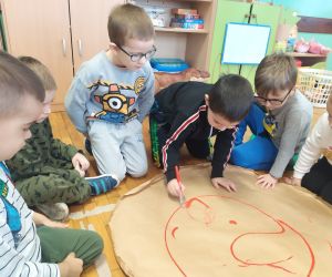 chłopiec rozprowadza czerwoną farbę na pizzy