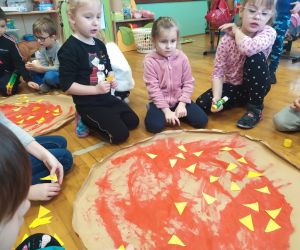 dzieci przyklejają ser do pizzy