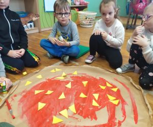 dzieci przyklejają ser do pizzy