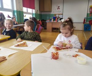 dzieci spożywają pizzę
