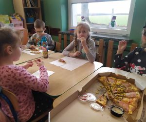 dzieci jedzą pizzę