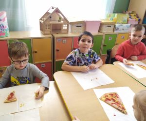 chłopcy spożywają pizzę