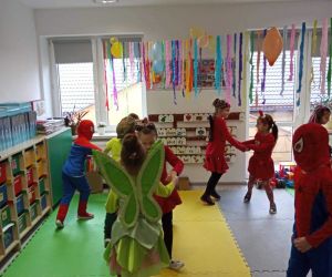 Przedszkolaki tańczą w przystrojonej sali przedszkolnej