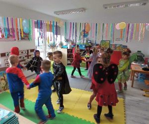 Przedszkolaki tańczą w przystrojonej sali przedszkolnej