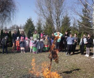 Grupa uczniów na placu przed szkołą obserwuje palenie Marzanny