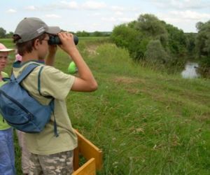 Dzieci, jedno patrzy przez lornetkę