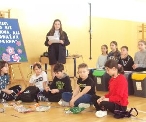 Uczniowie siedzą i  wcielają się w swoje role z zakresu edukacji ekologicznej 