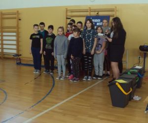 Uczniowie biorący udział w przedstawieniu stoją na tle dekoracji