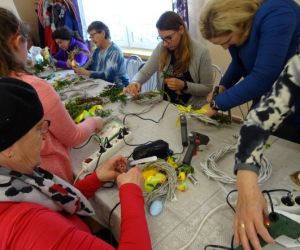 Osoby wykonują ozdoby wielkanocne podczas warsztatów