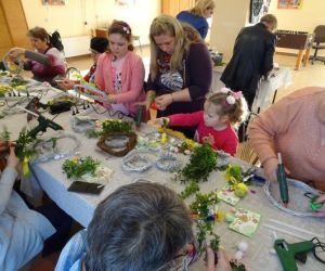 Osoby wykonują ozdoby wielkanocne podczas warsztatów