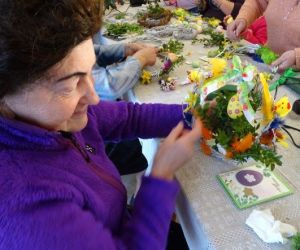 Osoby wykonują ozdoby wielkanocne podczas warsztatów